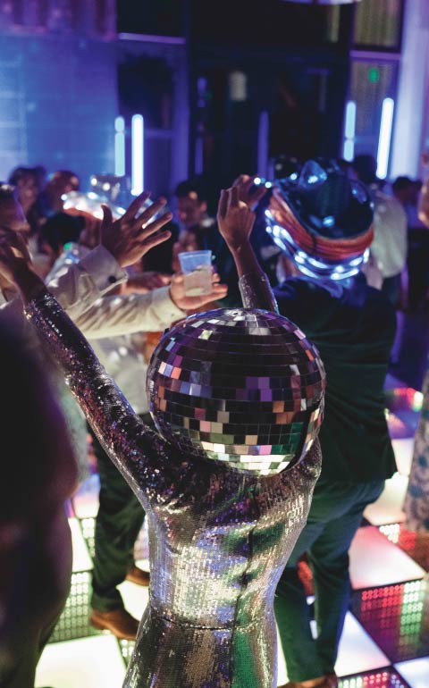 Corporate event dance floor with guests celebrating under neon lights in Charleston.