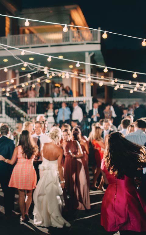 Outdoor Charleston wedding reception with café lights and dancing guests.