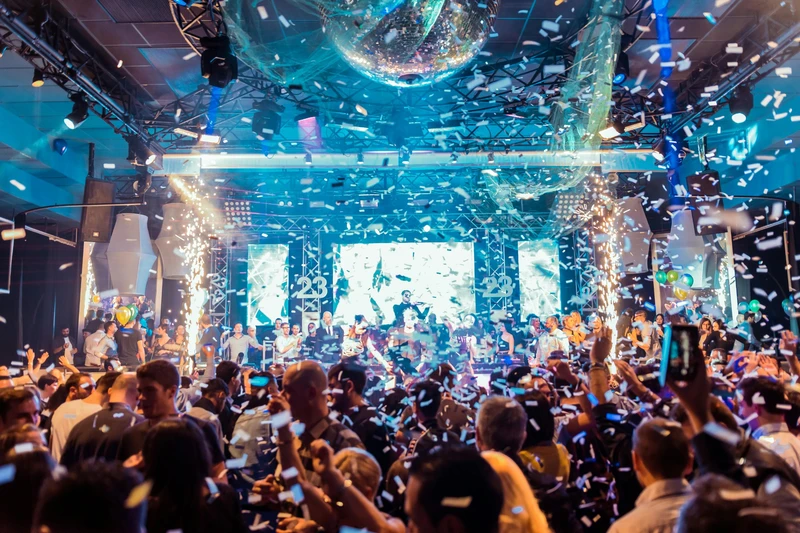 High-energy party lighting over a packed dance floor.